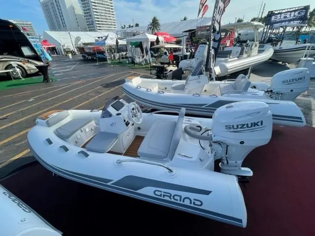 Slide: The Image of 2025 Grand Inflatables G340 boat with Suzuki engine displayed at a boat show. - 11