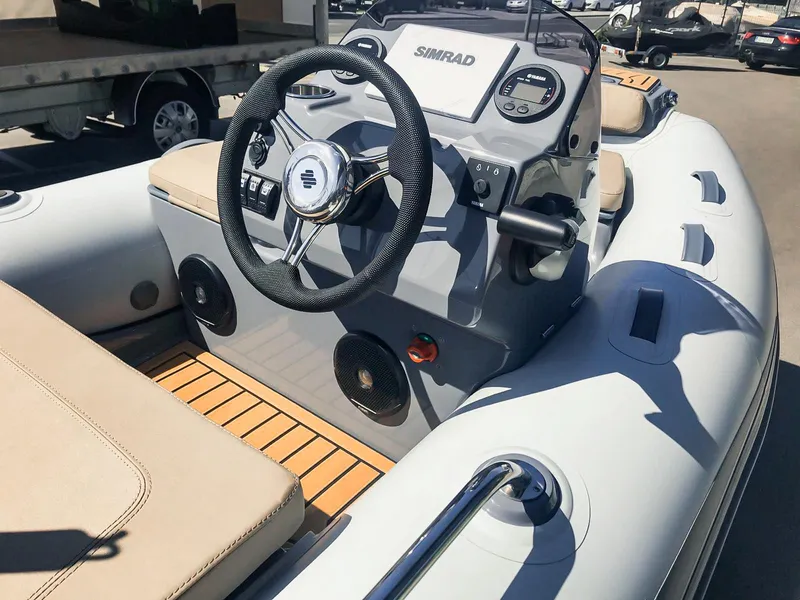 Slide: The Image of 2025 Grand Inflatables G340 boat interior with steering wheel and control panel. - 3