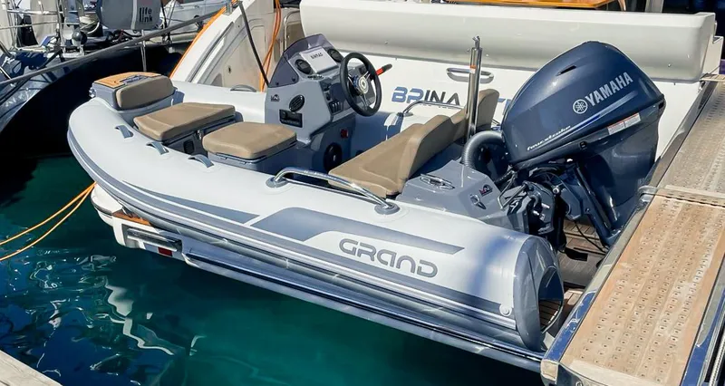 Slide: The Image of 2025 Grand Inflatables G340 boat with Yamaha engine docked in marina. - 5