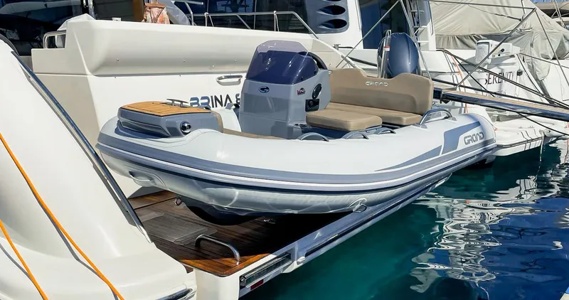 Slide: The Image of 2025 Grand Inflatables G340 boat docked at marina, featuring sleek design and modern amenities. - 6