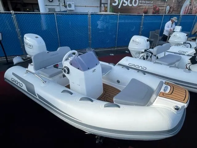 Slide: The Image of 2025 Grand Inflatables G340 boat with Suzuki engine, featuring sleek design and modern seating. - 7