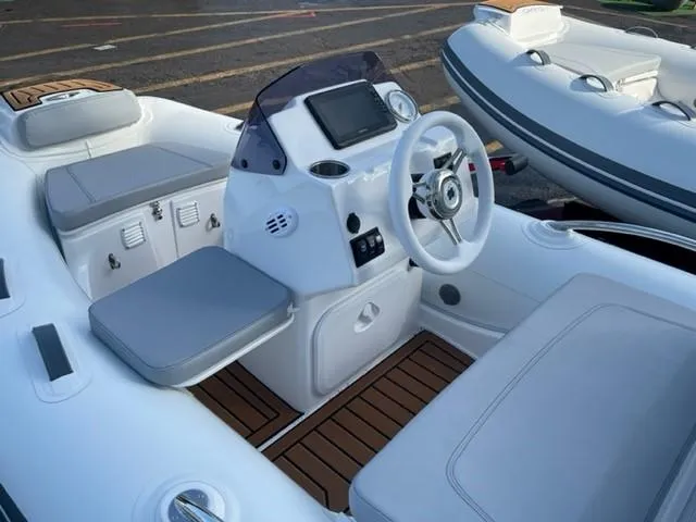 Slide: The Image of 2025 Grand Inflatables G340 boat interior with modern dashboard and seating. - 9