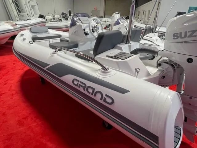Slide: The Image of 2025 Grand Inflatables G380 boat on display with Suzuki engine. - 2