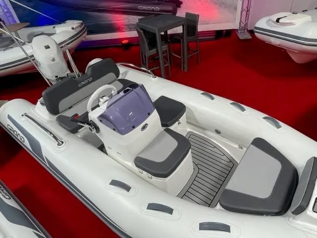 Slide: The Image of 2025 Grand Inflatables G380 boat on display with sleek design and modern seating. - 7