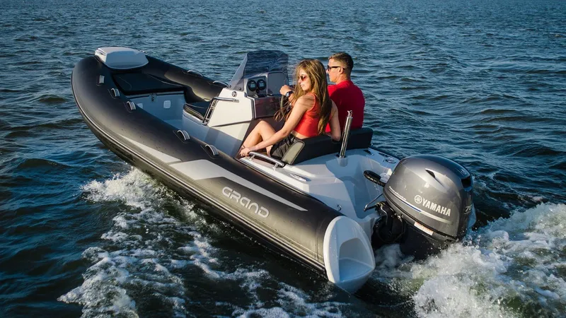 Slide: The Image of 2025 Grand Inflatables G420 boat cruising on open water with Yamaha engine. - 16