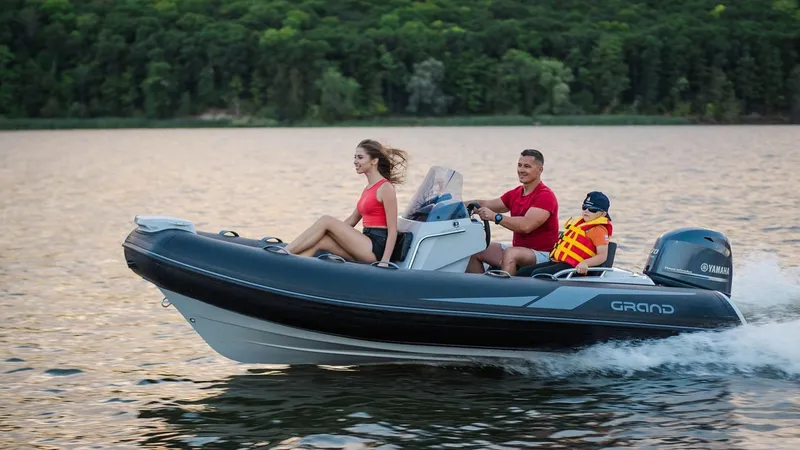 Slide: The Image of 2025 Grand Inflatables G420 boat cruising on a lake with passengers enjoying the ride. - 23