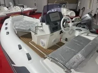 Slide: The Image of 2025 Grand Inflatables G420 boat interior with steering wheel and seating on display. - 6