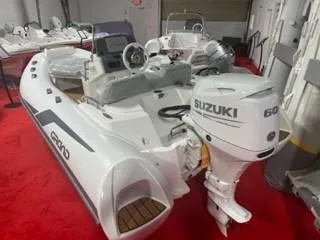 Slide: The Image of 2025 Grand Inflatables G420 boat with Suzuki 60 outboard motor on red carpet display. - 7