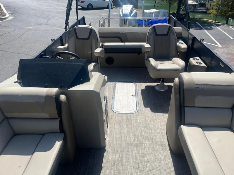 Slide: The Image of 2022 Viaggio Lago S pontoon boat interior with beige seating and steering console. - 27