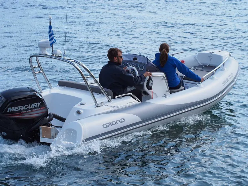 Slide: The Image of 2025 Grand Inflatables G500 boat cruising with two passengers on a calm sea. - 10