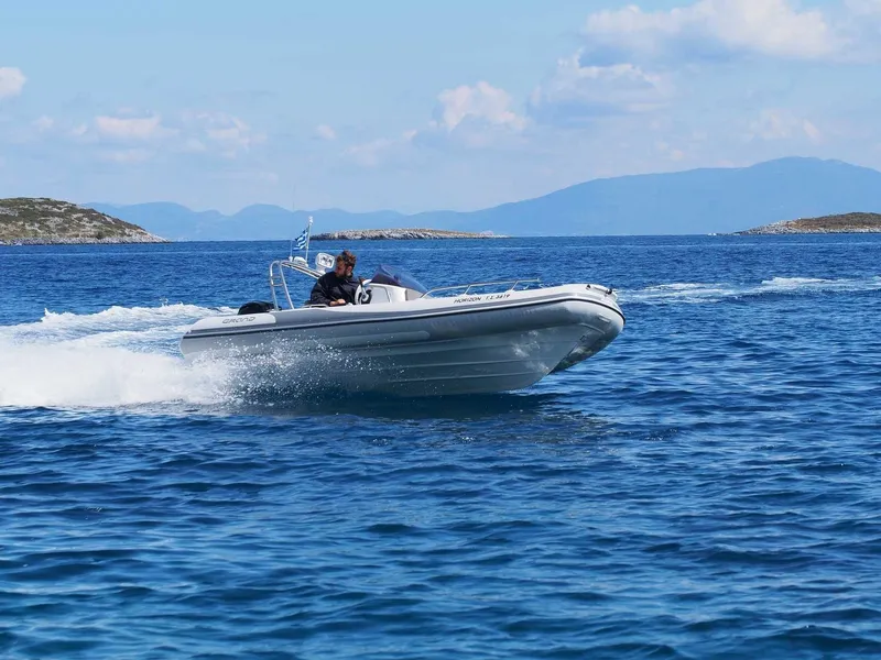 Slide: The Image of 2025 Grand Inflatables G500 boat cruising on open blue sea with distant islands. - 12