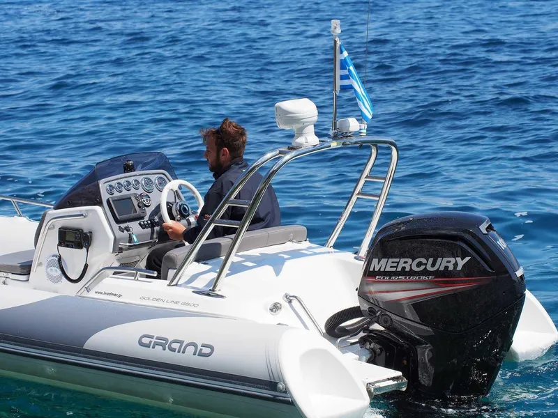 Slide: The Image of 2025 Grand Inflatables G500 boat with Mercury engine on clear blue water. - 13