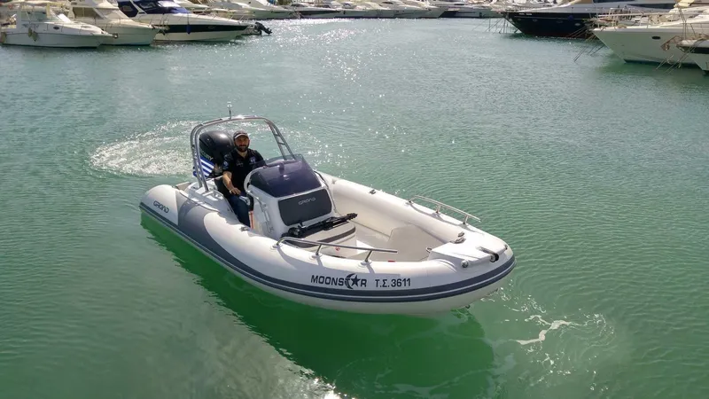 Slide: The Image of 2025 Grand Inflatables G500 boat cruising in a marina with calm green waters. - 14