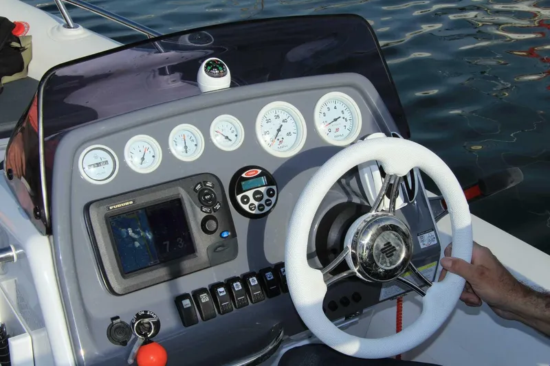 Slide: The Image of Control panel of 2025 Grand Inflatables G500 boat with steering wheel and gauges. - 9