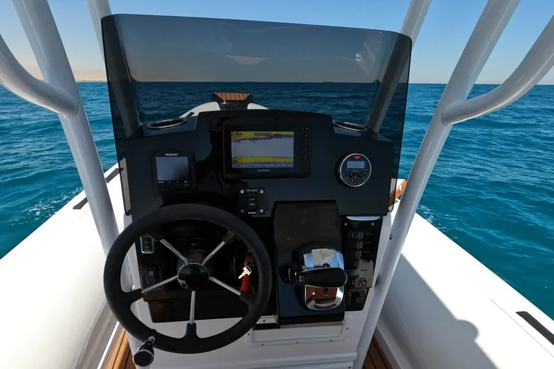Slide: The Image of 2025 Tiger Marine 740 PL boat dashboard with steering wheel and navigation equipment on open sea. - 18