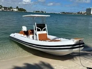 Slide: The Image of 2025 Tiger Marine 740 PL boat docked on a sandy beach with clear blue water. - 2