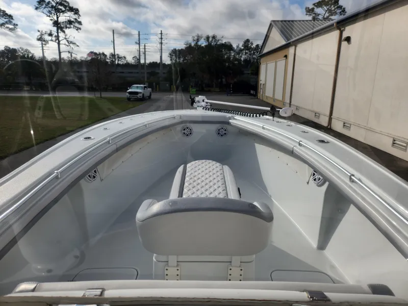 Slide: The Image of 2017 Yellowfin 34 Offshore boat interior with seating and speakers, parked outdoors. - 17