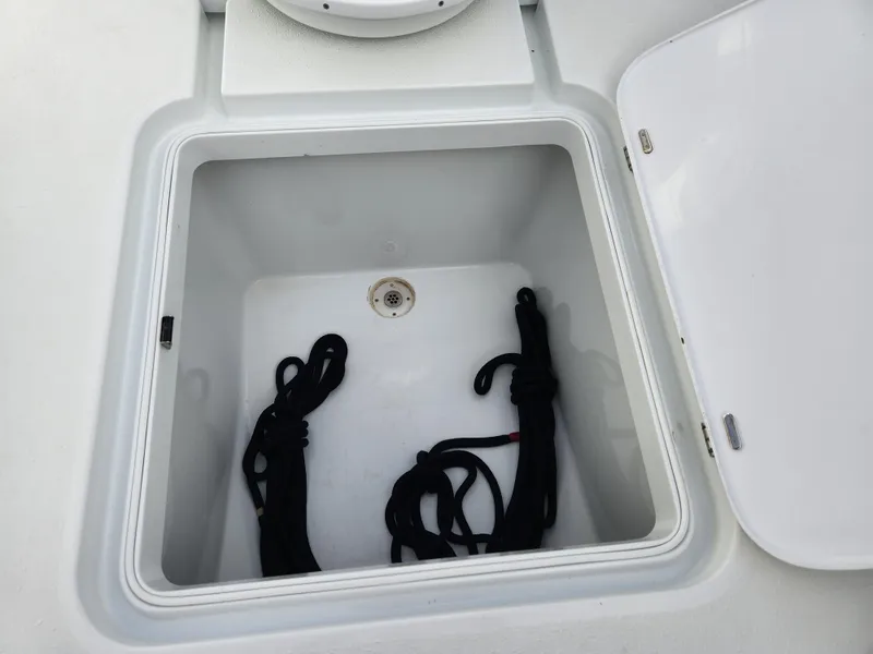 Slide: The Image of Open storage compartment on 2017 Yellowfin 34 Offshore boat with black ropes inside. - 35