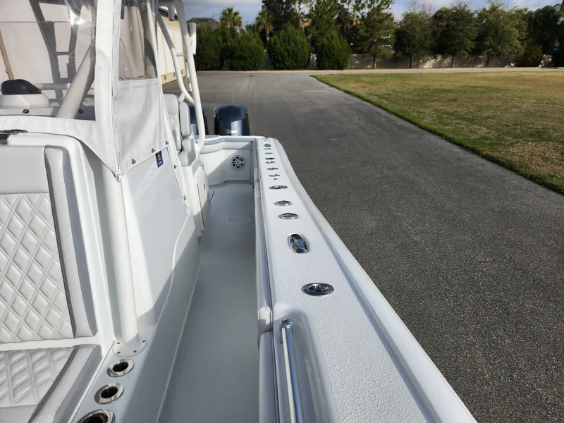 Slide: The Image of 2017 Yellowfin 34 Offshore boat, white interior, parked on a paved road near grass. - 39