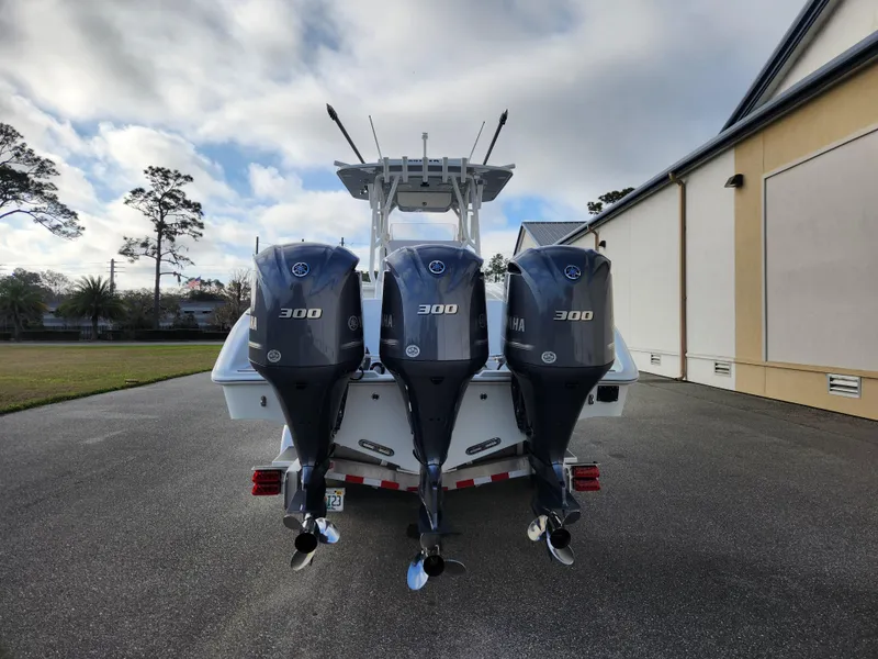 Slide: The Image of 2017 Yellowfin 34 Offshore boat with triple 300 horsepower engines, parked outdoors. - 8