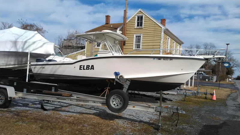 Slide: The Image of 1998 Ocean Master 31 CC boat on trailer, parked near a house. - 1