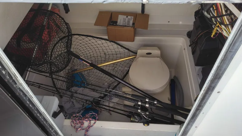 Slide: The Image of Interior of a 1998 Ocean Master 31 CC boat with fishing gear and a toilet. - 11