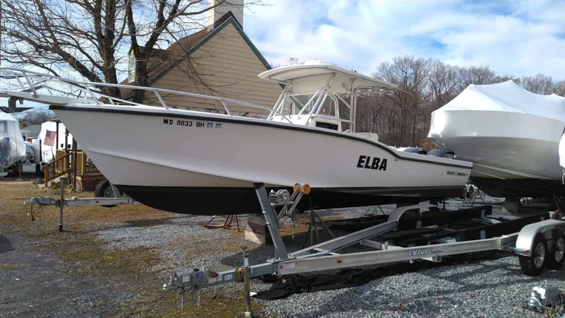 Slide: The Image of 1998 Ocean Master 31 CC boat on trailer, named "ELBA," parked outdoors. - 2