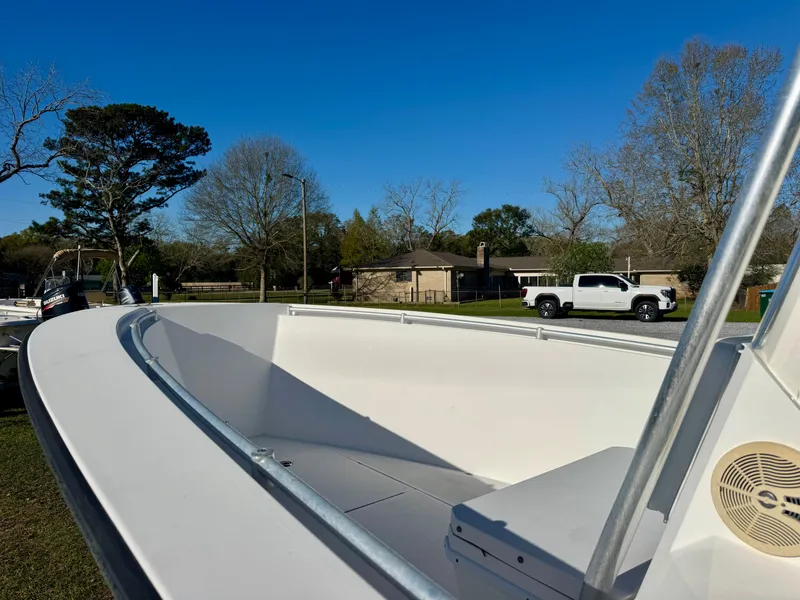 Slide: The Image of 2008 Contender 21 Open boat on land, with trees and a white truck in the background. - 5