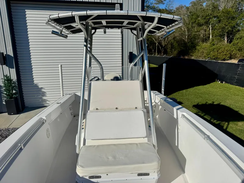 Slide: The Image of 2008 Contender 21 Open boat with T-top, docked near a metal building. - 9