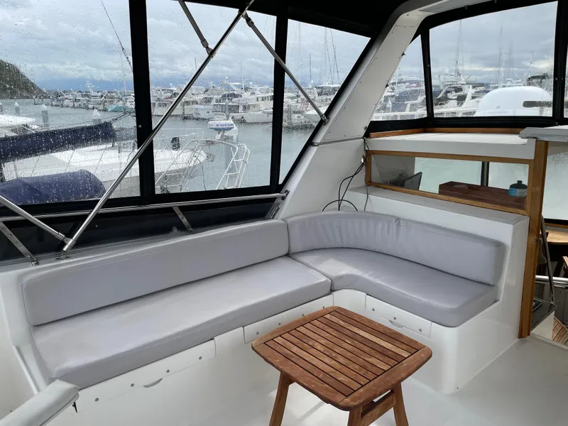 Slide: The Image of 1987 Lien Hwa 47' Mark III Sundeck Yacht interior with cushioned seating and wooden table. - 13