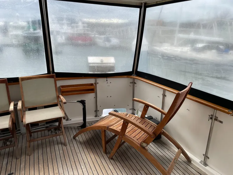 Slide: The Image of 1987 Lien Hwa 47' Mark III yacht sundeck with wooden chairs and marina view. - 18