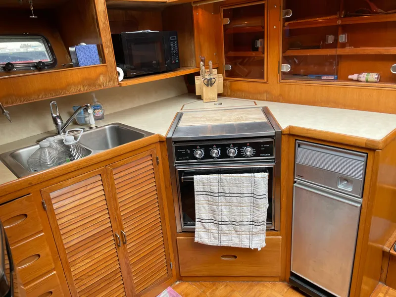 Slide: The Image of 1987 Lien Hwa 47' yacht kitchen with stove, sink, and wooden cabinetry. - 29