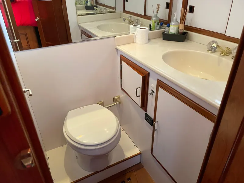 Slide: The Image of 1987 Lien Hwa 47' Mark III yacht bathroom with sink, toilet, and storage cabinets. - 32