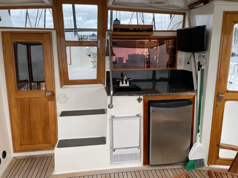 Slide: The Image of 1987 Lien Hwa 47' Mark III yacht interior with kitchenette, wood accents, and modern appliances. - 5