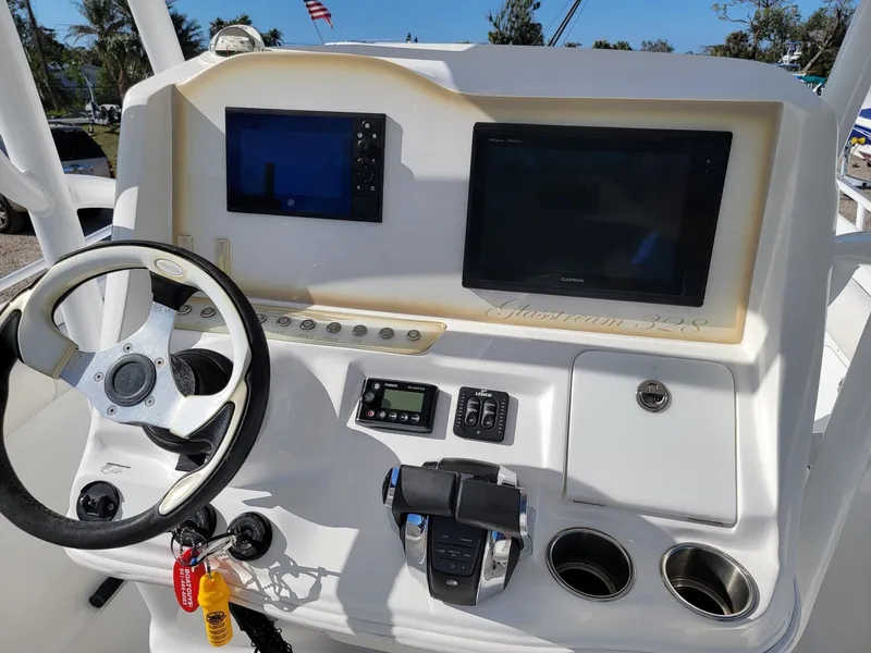 Slide: The Image of 2018 Glasstream 328SCX boat dashboard with steering wheel, navigation screens, and controls. - 6