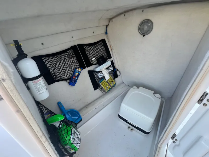 Slide: The Image of 2008 NauticStar 2000 DC boat interior with storage nets and portable toilet. - 15
