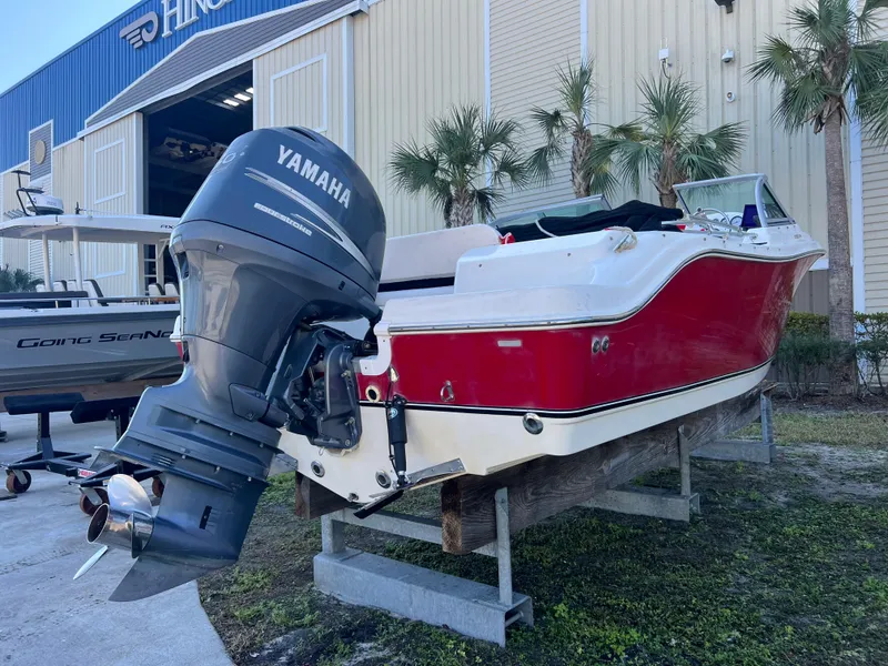 Slide: The Image of 2008 NauticStar 2000 DC boat with Yamaha outboard motor, parked near a building. - 6