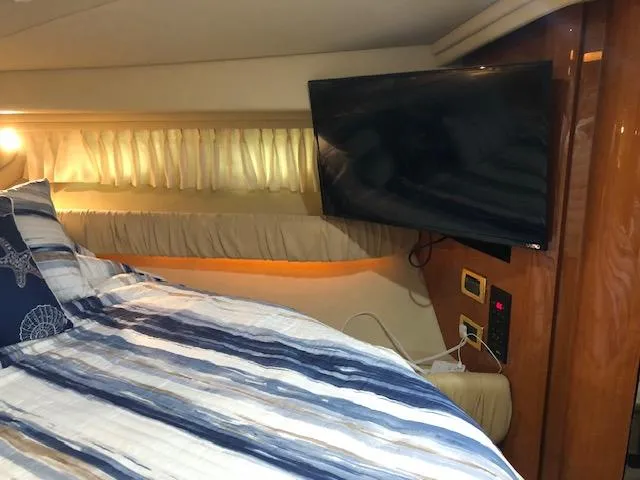 Slide: The Image of Interior of 2001 Sea Ray 410 Sundancer with bed, TV, and wood paneling. - 15
