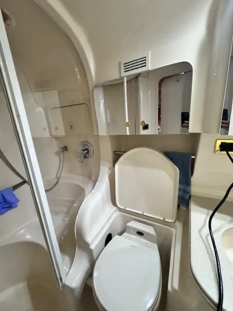 Slide: The Image of 2001 Sea Ray 410 Sundancer bathroom with shower, toilet, and mirror. - 17