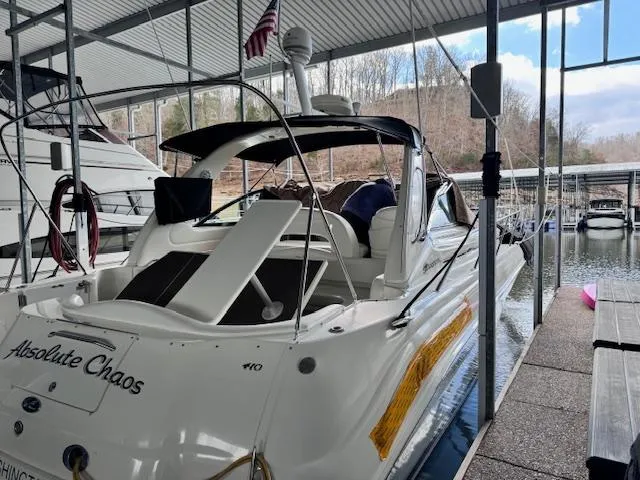 Slide: The Image of 2001 Sea Ray 410 Sundancer docked, featuring sleek design and spacious deck. - 2