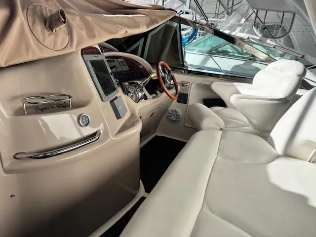 Slide: The Image of Interior of 2001 Sea Ray 410 Sundancer yacht with beige seating and modern dashboard. - 23
