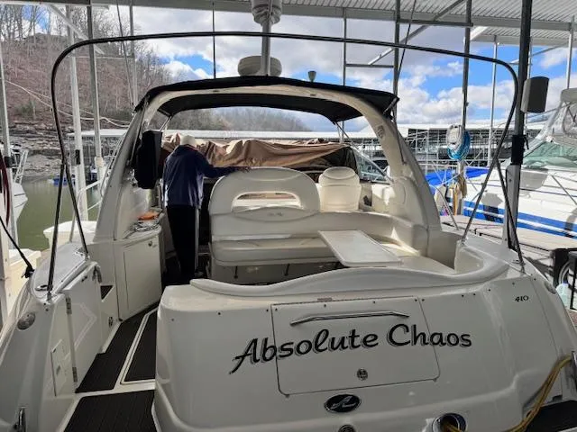 Slide: The Image of 2001 Sea Ray 410 Sundancer yacht docked, featuring spacious seating and "Absolute Chaos" name. - 25