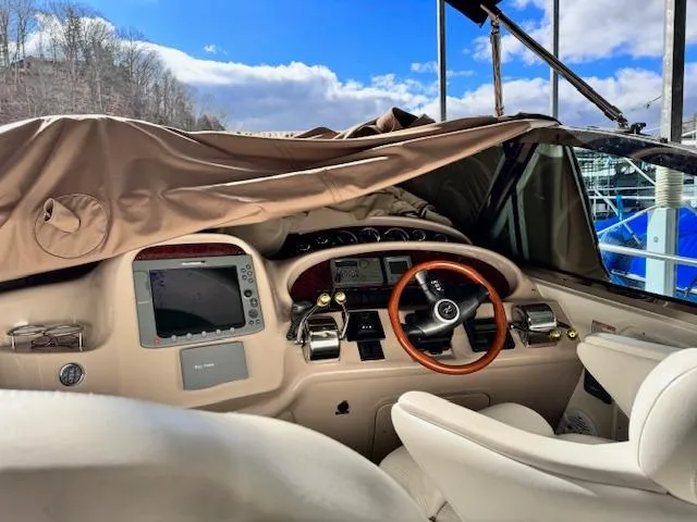 Slide: The Image of 2001 Sea Ray 410 Sundancer helm with covered dashboard and wooden steering wheel. - 3