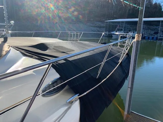 Slide: The Image of 2001 Sea Ray 410 Sundancer yacht docked by a serene lake. - 4