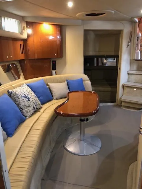Slide: The Image of Interior of 2001 Sea Ray 410 Sundancer with beige seating and blue cushions. - 7