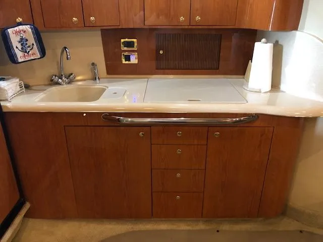 Slide: The Image of 2001 Sea Ray 410 Sundancer kitchen with wooden cabinets, sink, and countertop. - 9