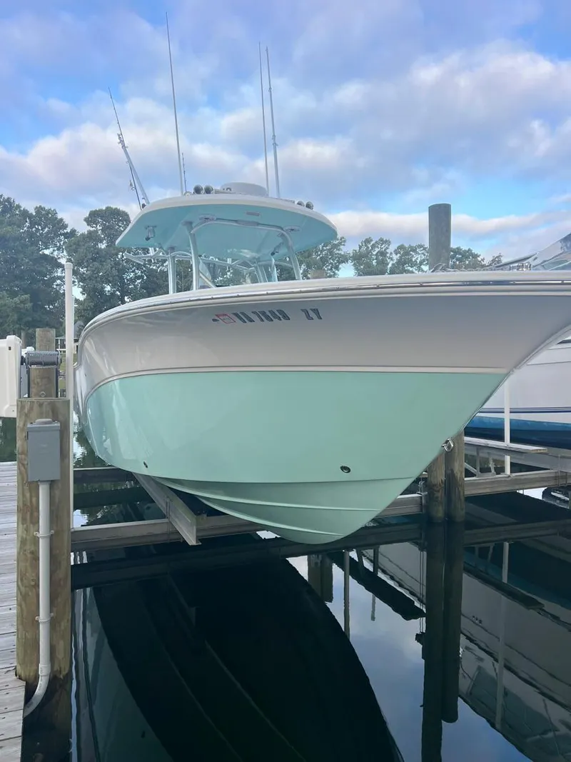 Slide: The Image of 2015 Sea Fox 286 Commander boat docked, light blue hull, overcast sky. - 15
