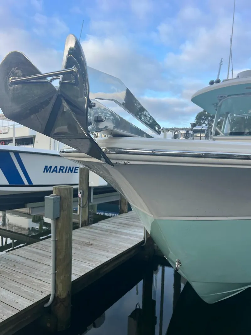 Slide: The Image of 2015 Sea Fox 286 Commander boat docked, featuring sleek design and stainless steel anchor. - 18