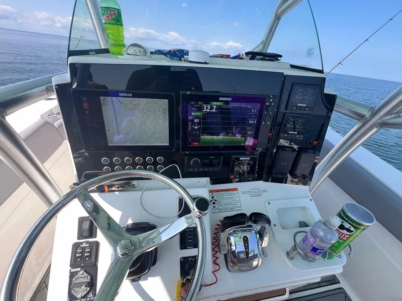 Slide: The Image of Control panel of a 2015 Sea Fox 286 Commander boat with navigation screens and steering wheel. - 2