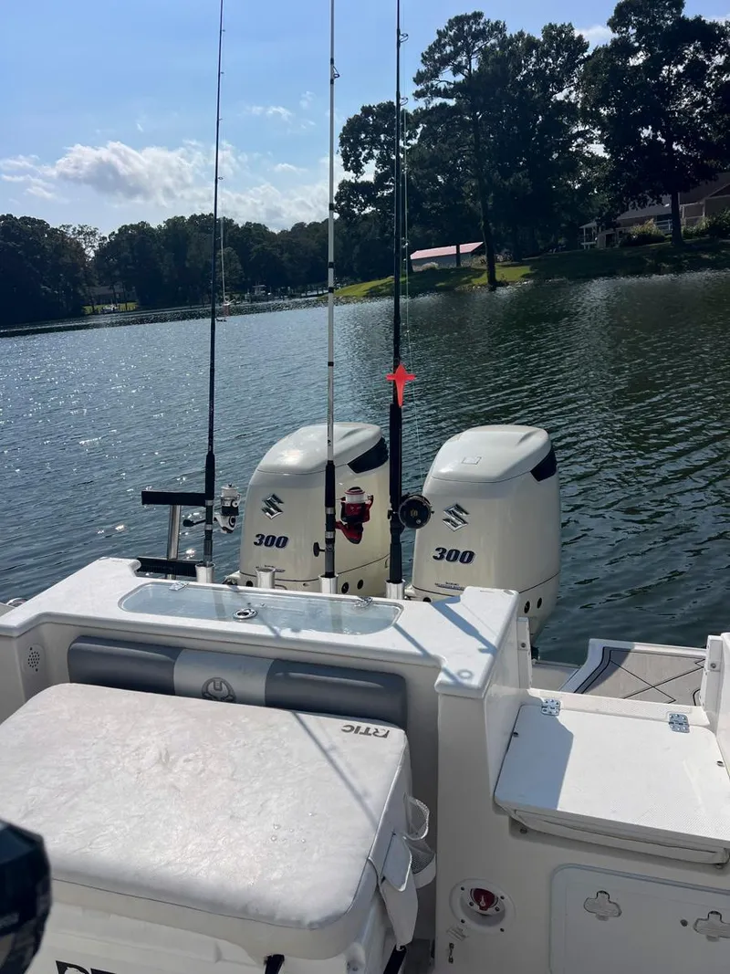 Slide: The Image of 2015 Sea Fox 286 Commander boat with dual Suzuki 300 engines on a serene lake. - 7